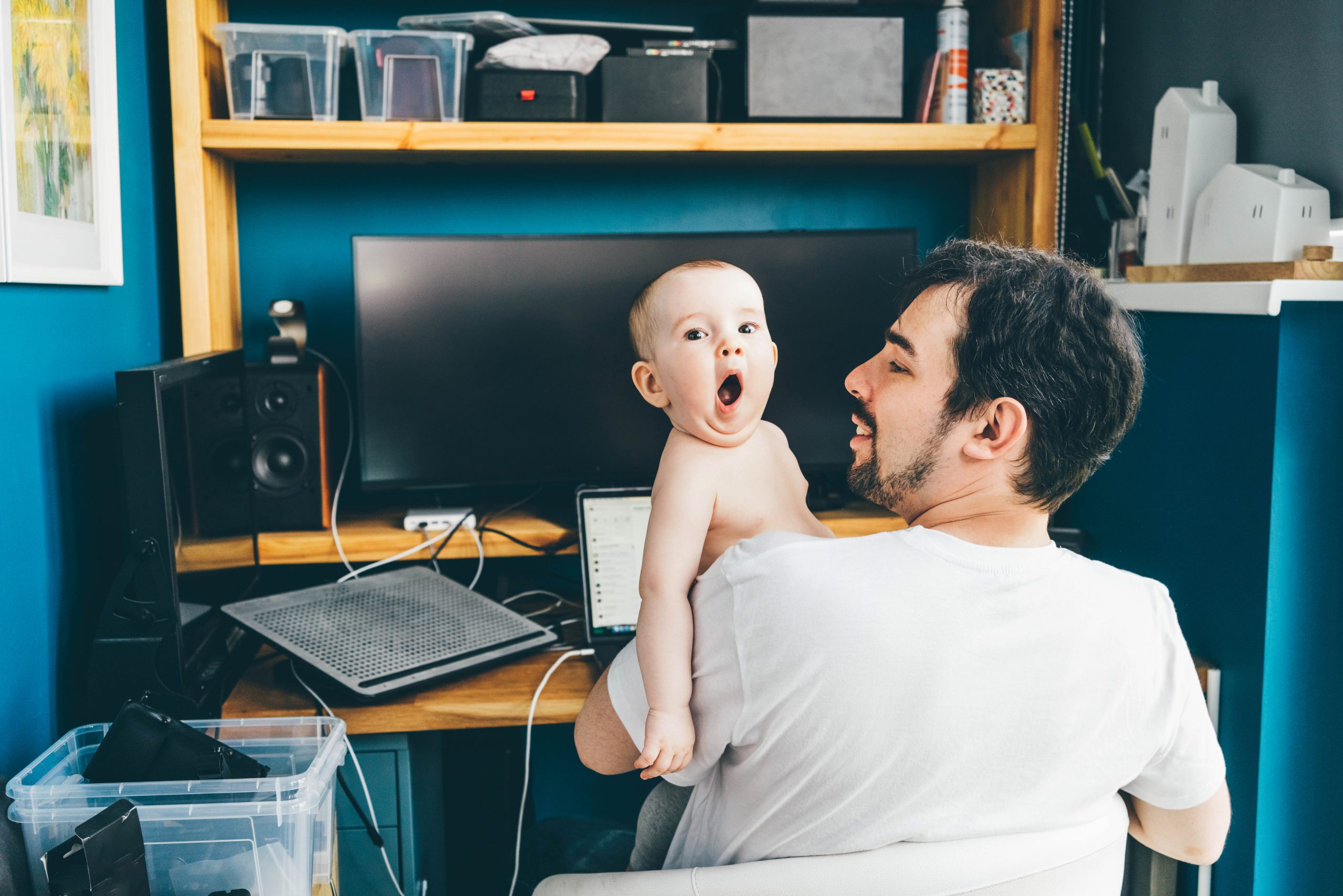 Father working from home with chilld in his arms