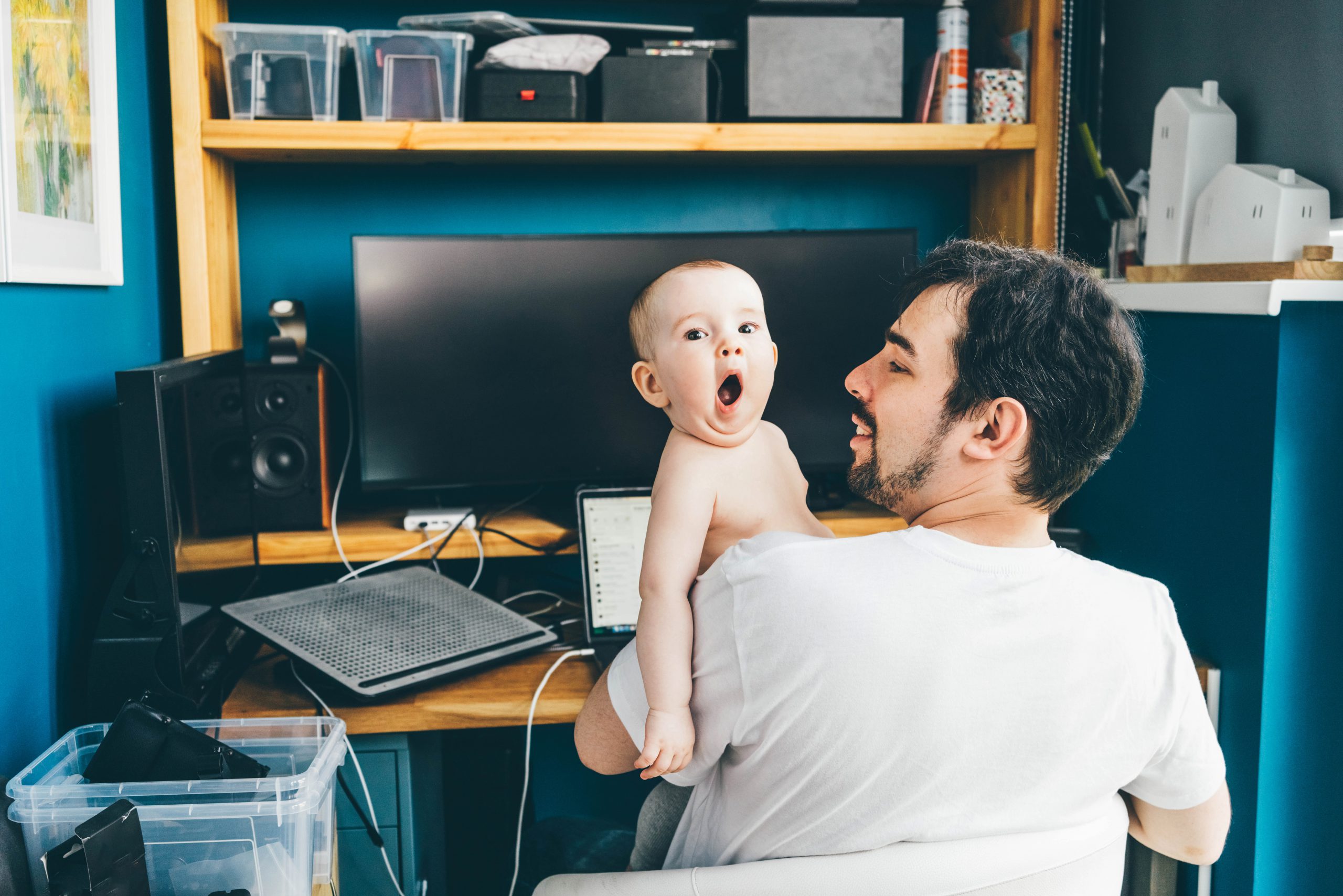 Father working from home with chilld in his arms